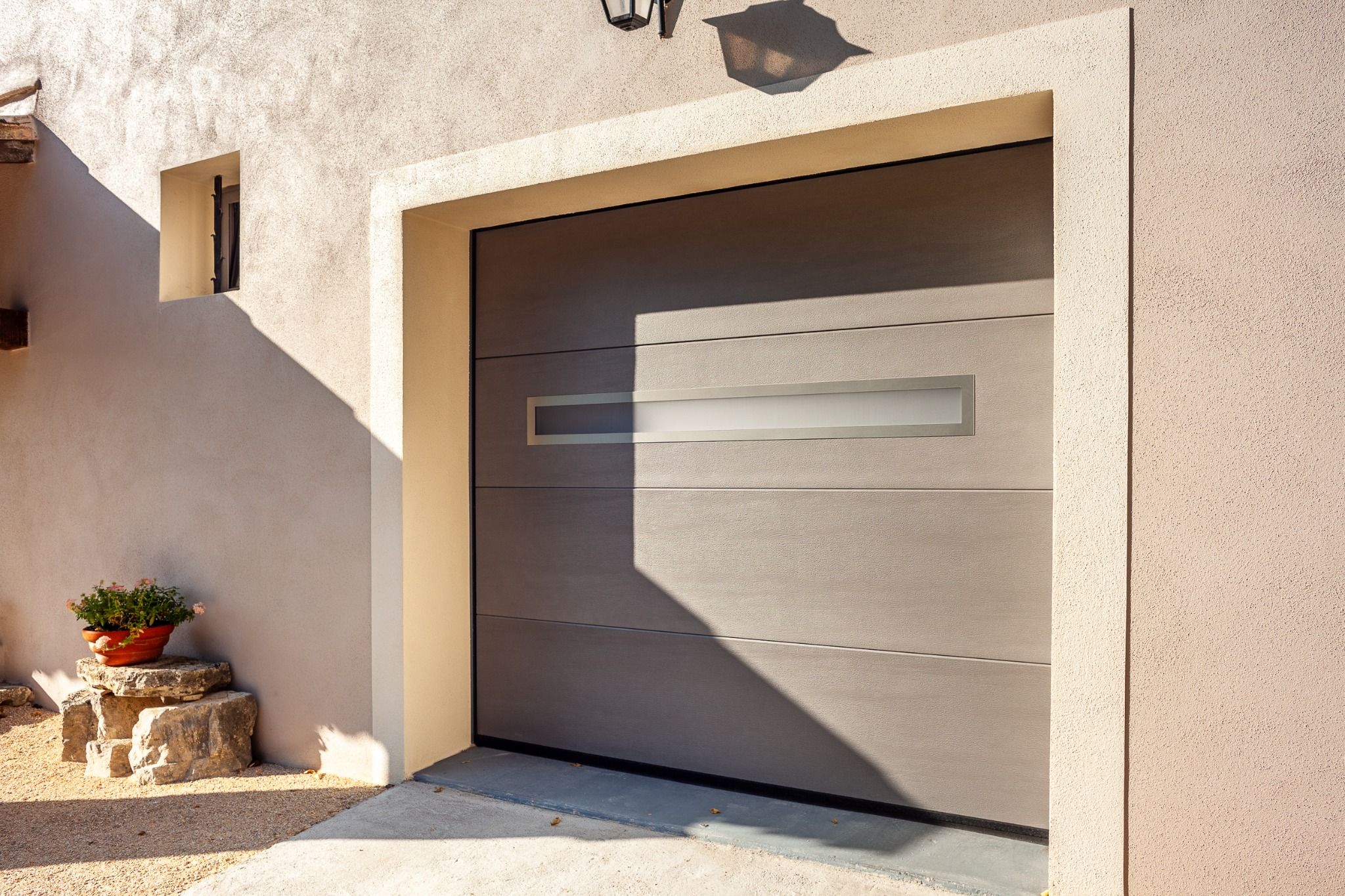 Luminosité dans le garage grâce aux hublots design d'une porte de garage sectionnelle